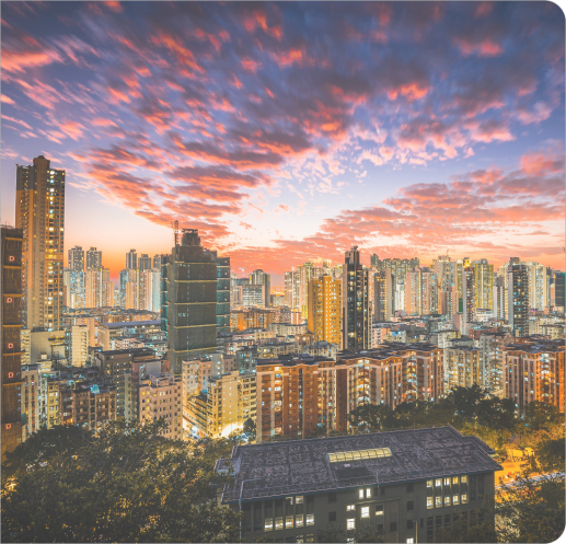 Vista de uma cidade com prédios iluminados ao entardecer